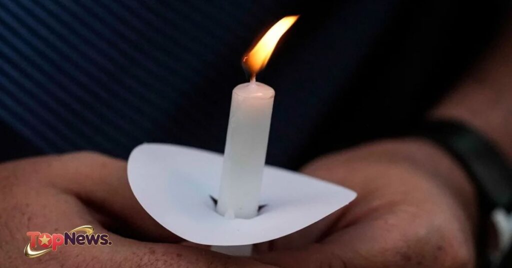 Mark Gorman holds a candle during a vigil Wednesday